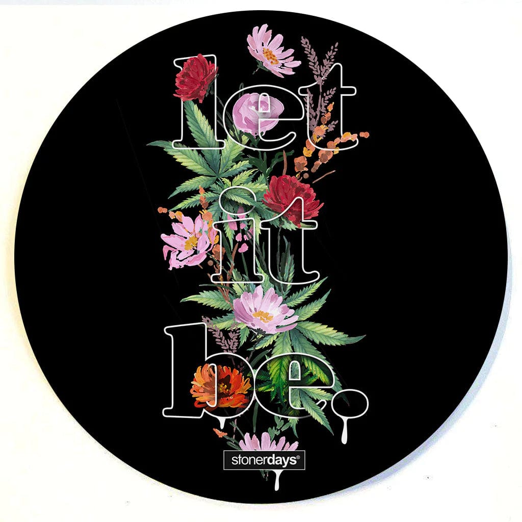 A vibrant floral arrangement surrounds the circular Stonerdays Round Dab Mats, shot from a top-down perspective.