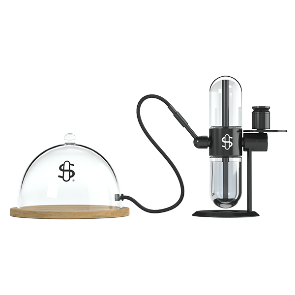 Front-facing shot of the Tray Cloche showing a clear glass dome on a wooden base connected by a black hose to its vertical black vaporizer.