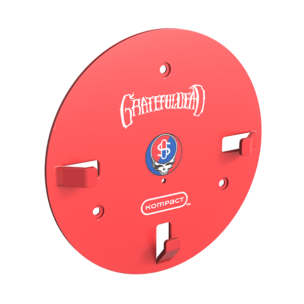 Angled view of the red Grateful Dead x Stündenglass Kompact Wall Mount showing band logo and skull emblem on its circular face with three mounting tabs.