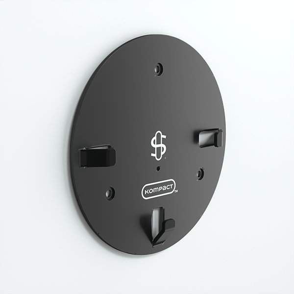 Angled view of the black Kompact Wall Mount round plate fixed to a white wall, showing three hooked clips and center logo.