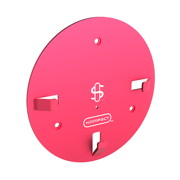 Angled view of the pink Kompact Wall Mount (Pink) showing its round plate, three tabs, logo and mounting holes against a white background