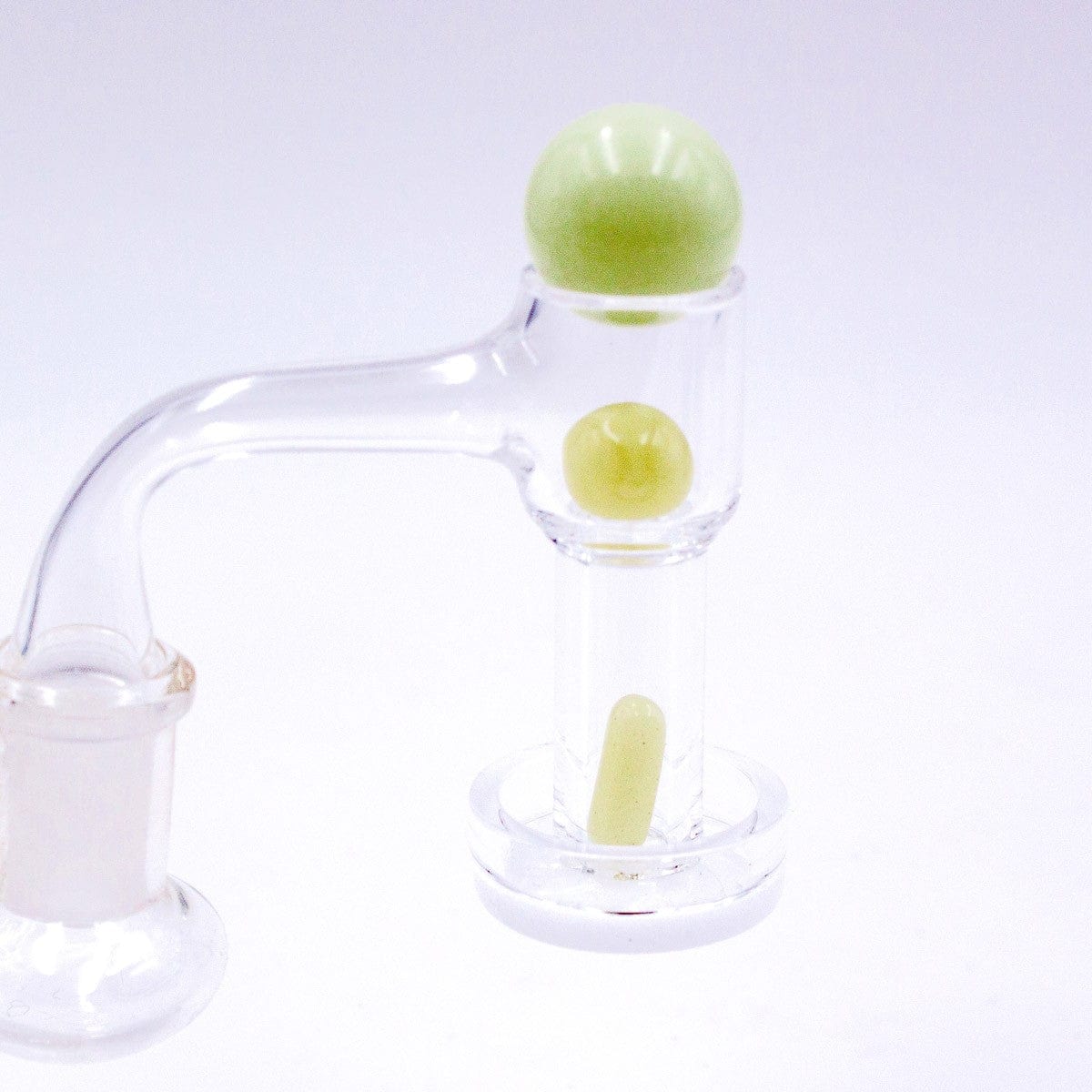 A close-up, angled view of the Glow in The Dark Glass Terp Slurper Set, featuring a clear glass piece with a glowing green accent.