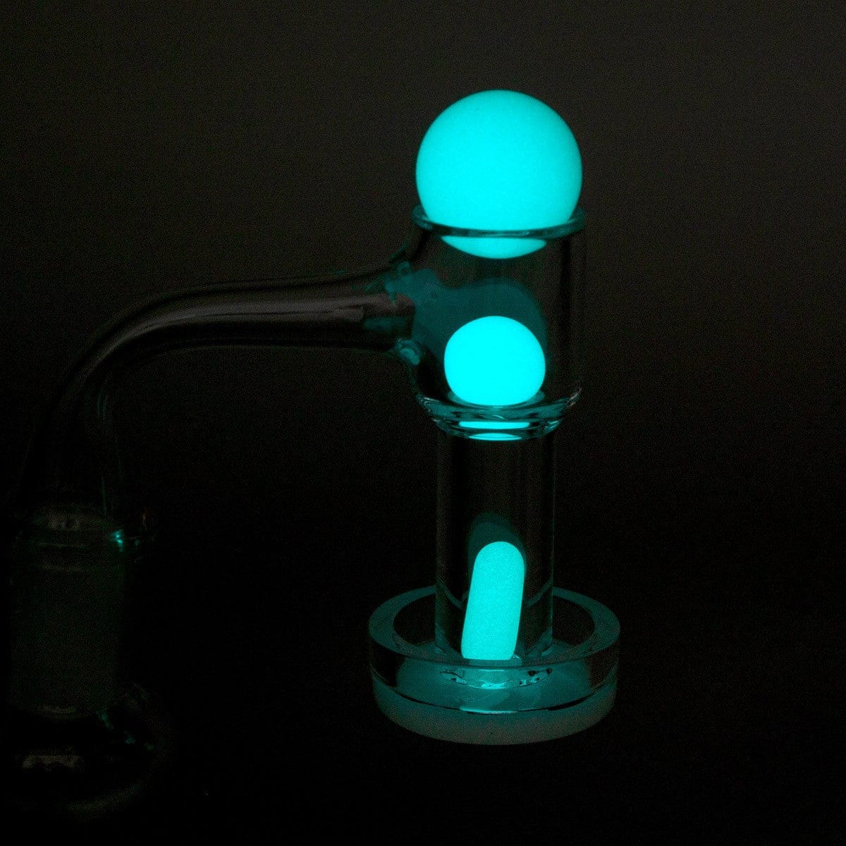 Front view of the glowing-in-the-dark glass Terp Slurper Set, presented as a luminous orb against a dark background.