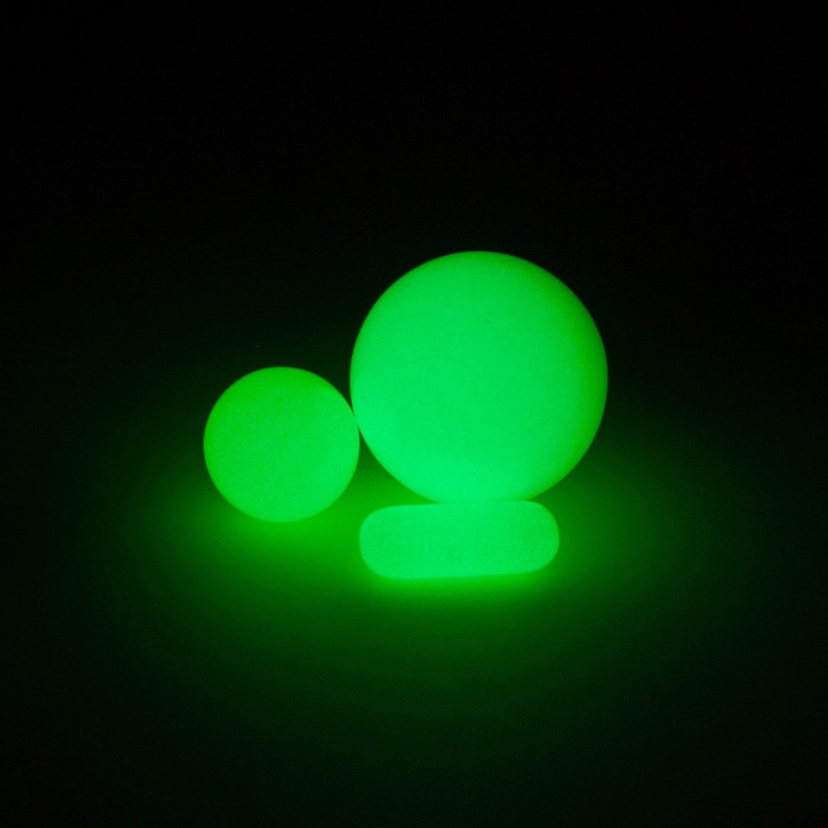 Front view of the glowing green glass pieces from the Glow in The Dark Glass Terp Slurper Set, set against a dark backdrop.