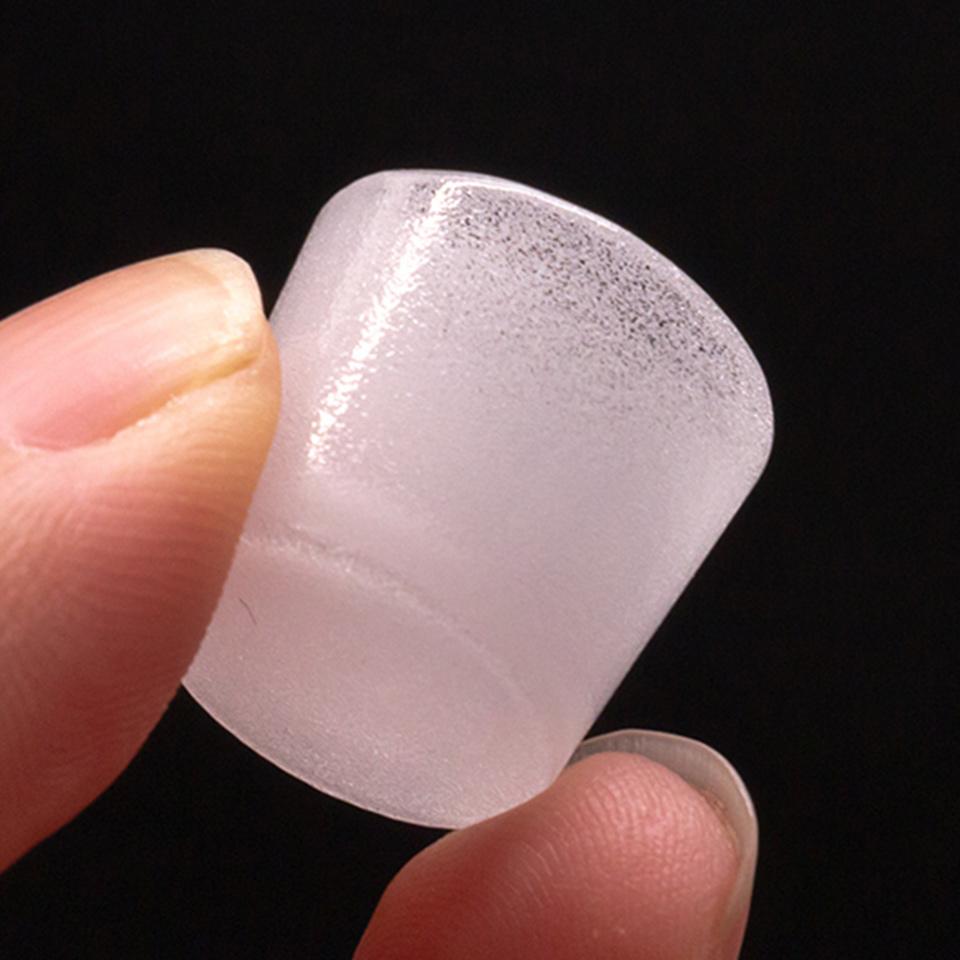 A close-up, angled view of the Puffco Peak Gavel Bowl held against a dark background, showing its clear glass construction.