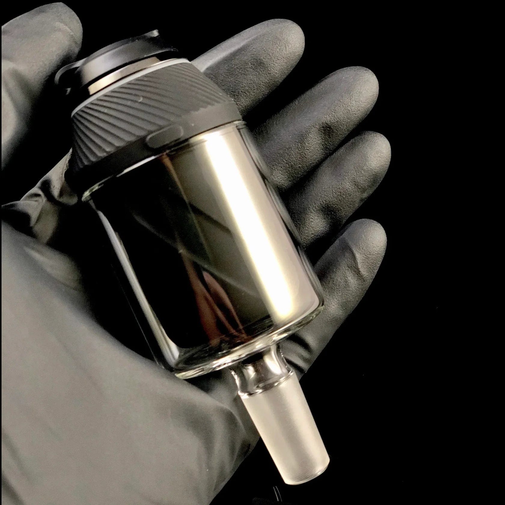 A close-up, angled view of the Proxy Glass Adapter held against a dark, blurred background.