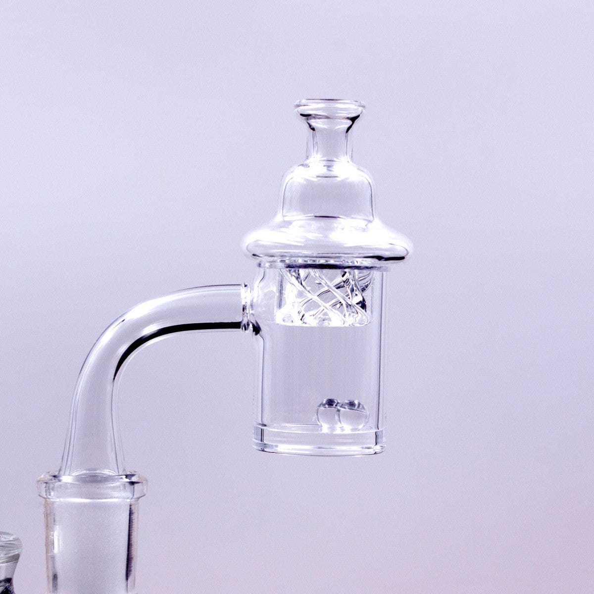 Close-up of the Quartz Banger Set with Spinning Carb Cap and Terp Pearls, showcasing the clear glass and swirling internal design.