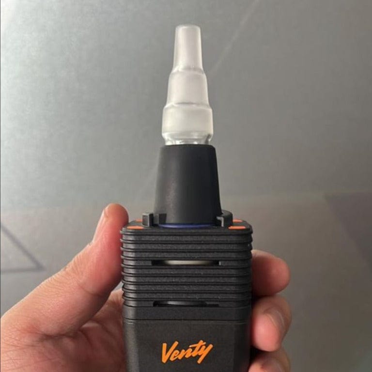 Close-up of the Venty Vaporizer 3 in 1 Glass Water Pipe Adapter held in a hand, highlighting its glass connection.