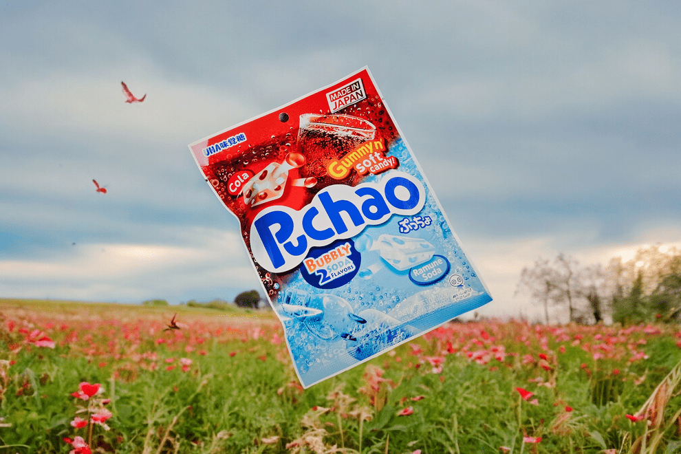 Front view of the Puchao Chewy Candy package against a blurred, colorful floral background.