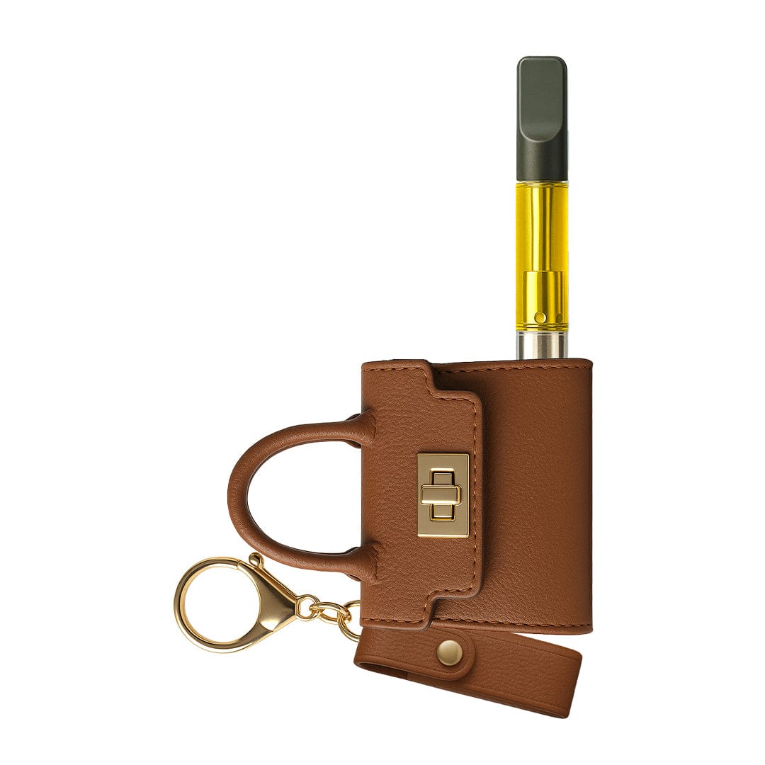 Top-down view of a brown leather mini purse keychain holding a slim gold cartridge, showing the Penjamin Pursejamin Vaporizer inserted and a gold-tone clasp.