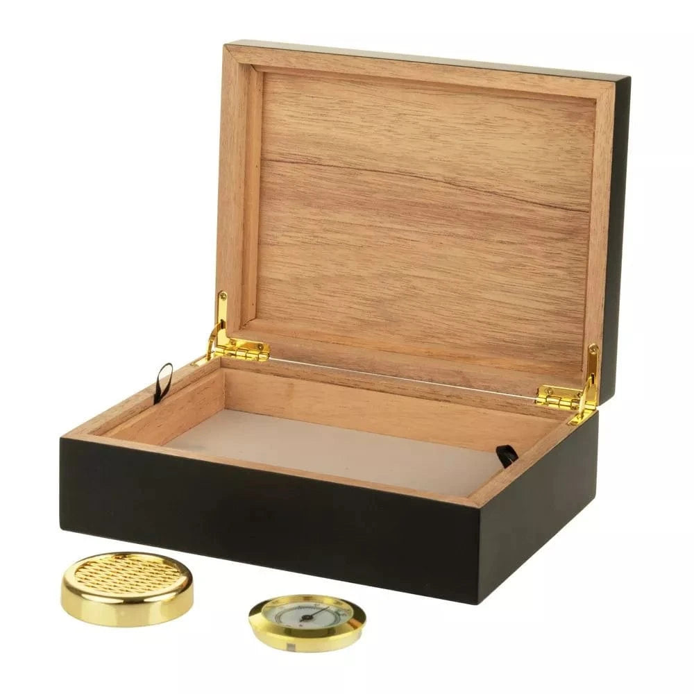 Angled view of the open Sigaro Personal Humidor Wood Box with Hygrometer | Black showing its natural wood interior, black exterior, gold hinges, and the separate gold hygrometer and humidifier on a white background