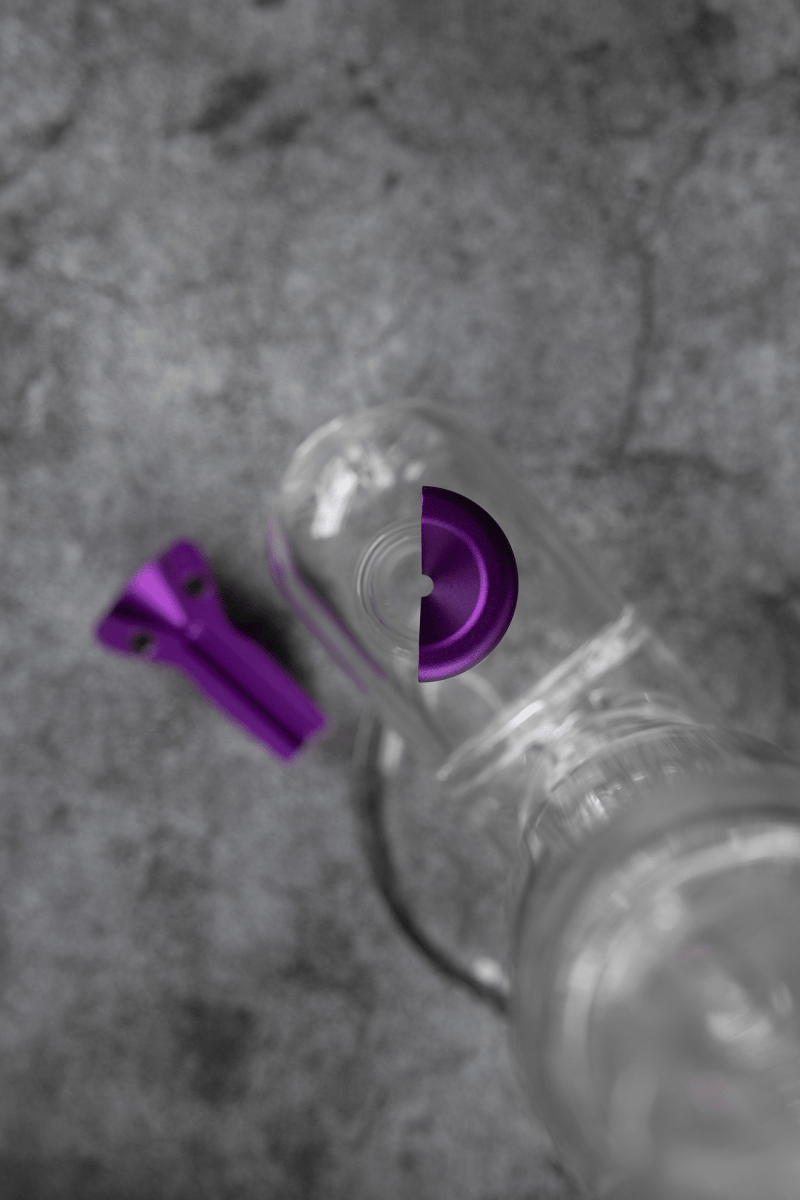 Overhead view of the Bowlz V3| showing a clear glass piece with a unique, rounded shape on a textured gray surface.