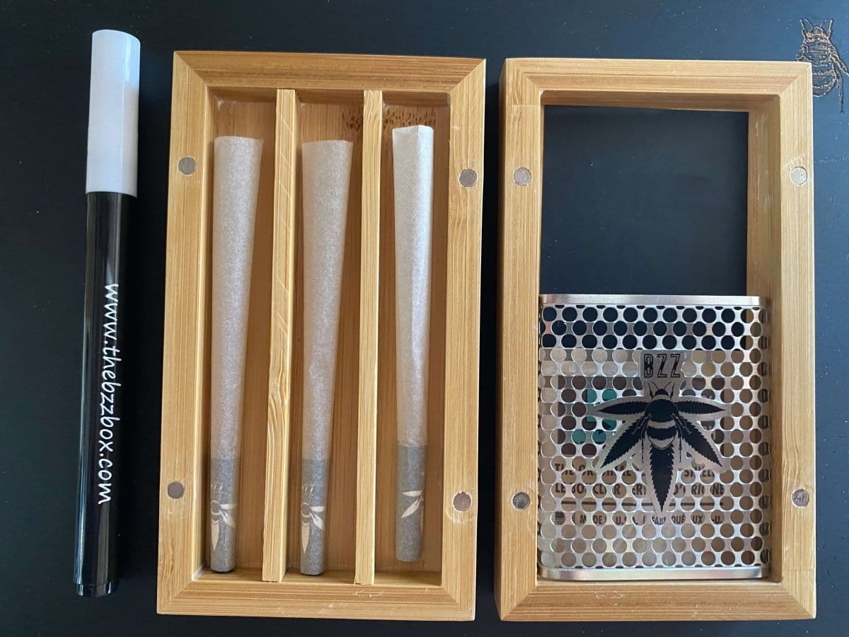 Front view of The Bzz Ritual (Bzz Mini) sticks arranged inside a black case, on a dark surface.