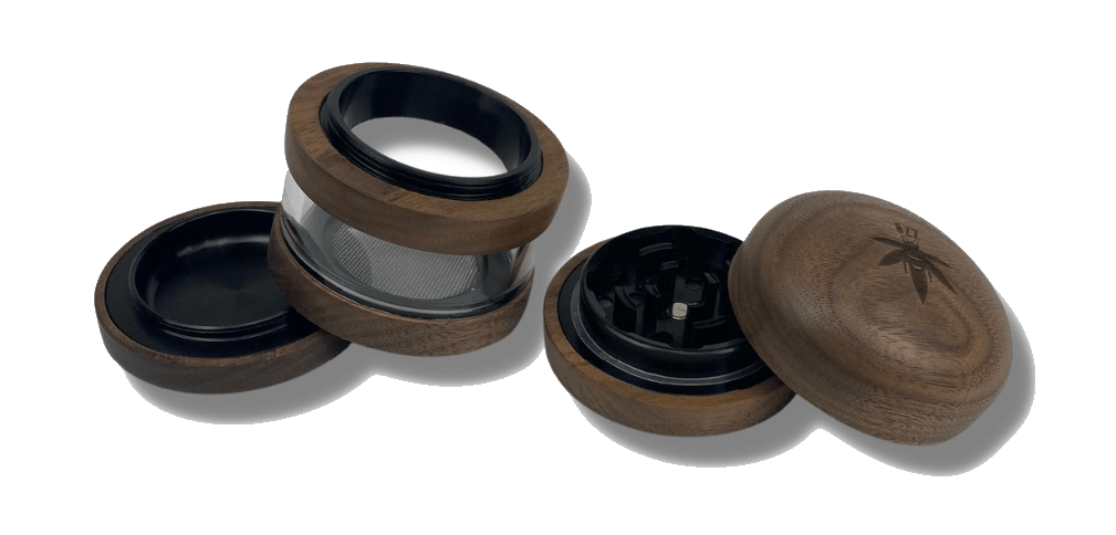 Overhead view of The Bzz 4 Piece Grinder, with its four metallic sections separated on a dark surface.