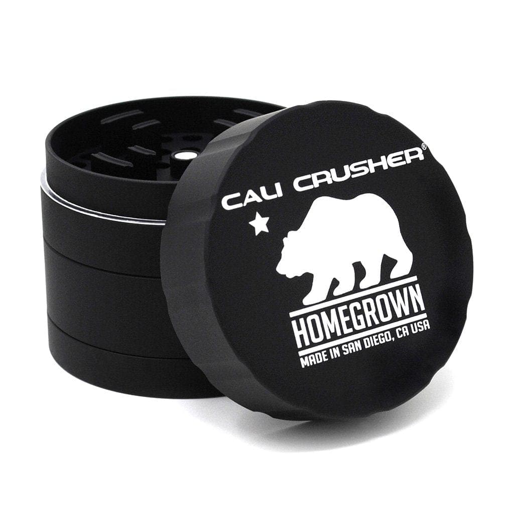 A close-up, angled view of the four-piece Cali Crusher Homegrown Grinder, showcasing its metallic finish and circular design.