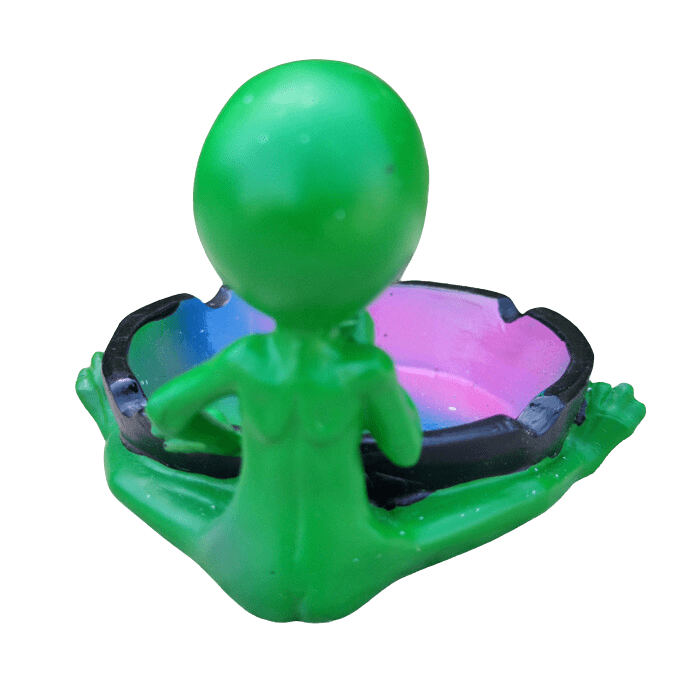 A side view of the Ceramic Smoking Alien Ashtray Ash Catcher, depicting a green alien figure holding a dark-colored ashtray.
