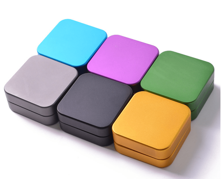 A top-down view of the 2 Piece Aluminum Square Grinder in various metallic finishes, arranged against a plain white background.