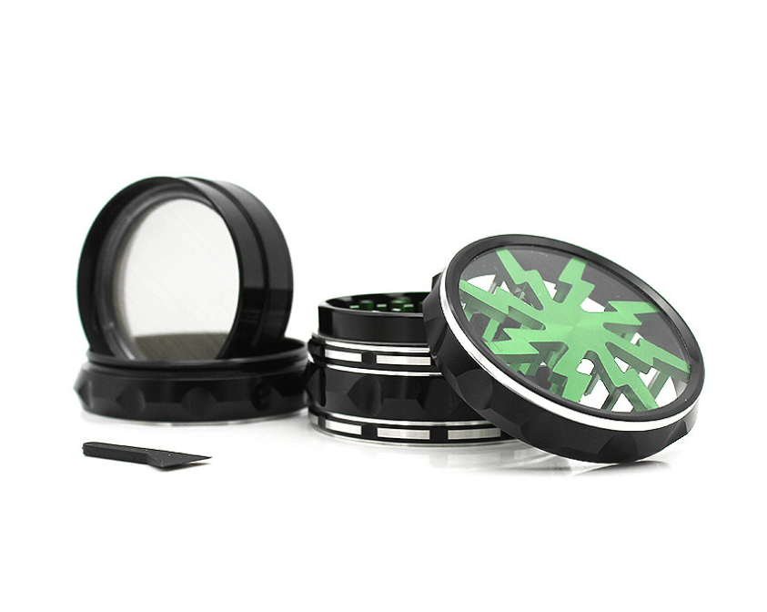 A disassembled 4 Piece Aluminum Lighting Teeth Grinder, shown from above with its four parts arranged in a row on a white surface.