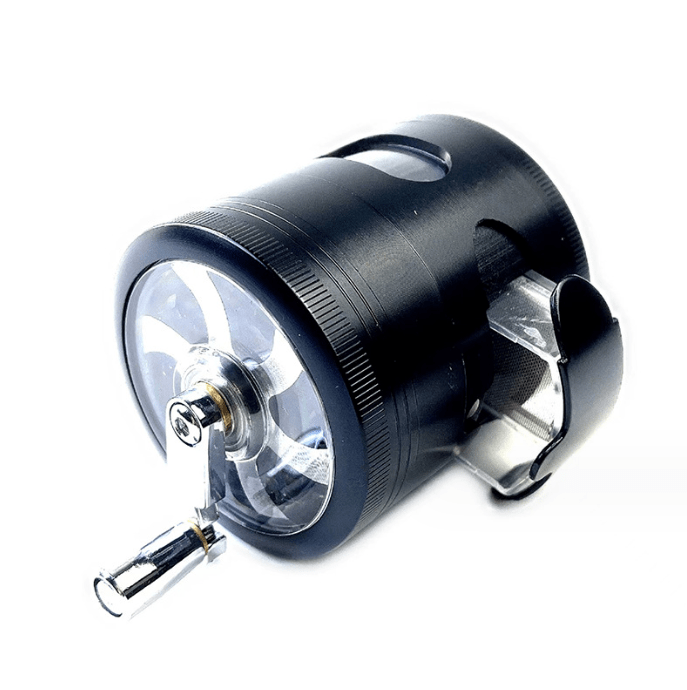 A close-up, angled view of the 3.5" 4 Piece Hand Crank Grinder with Chamber Window, showing a clear chamber and metallic grinding components.