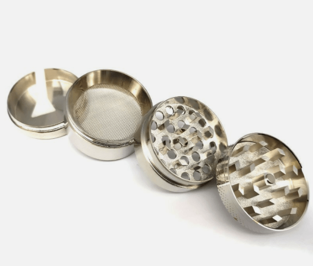 A disassembled 4-Piece Zinc Grinder shows its metal components arranged in a circular pattern against a plain white background.