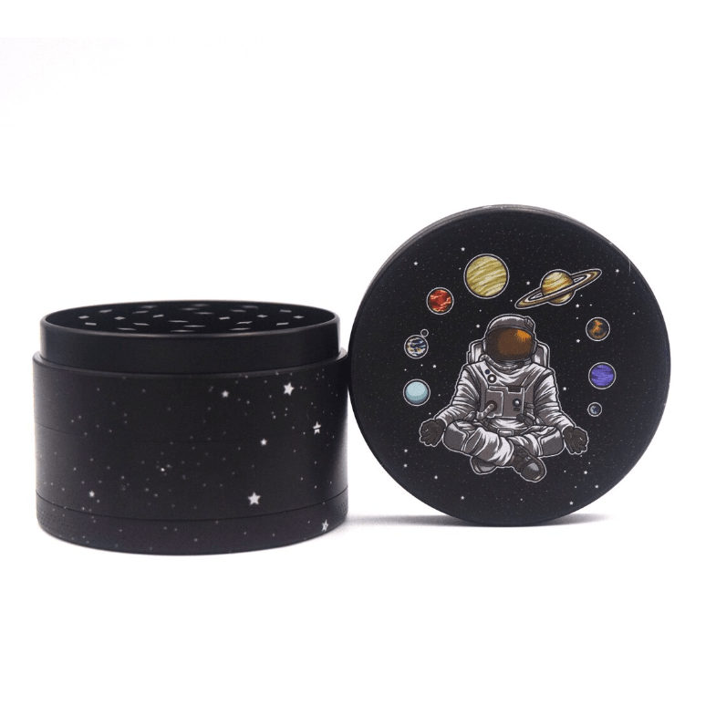 Front view of the 4 Piece 2.5" Trip to the Moon Grinder, showcasing a celestial design on its dark-colored, multi-part construction.