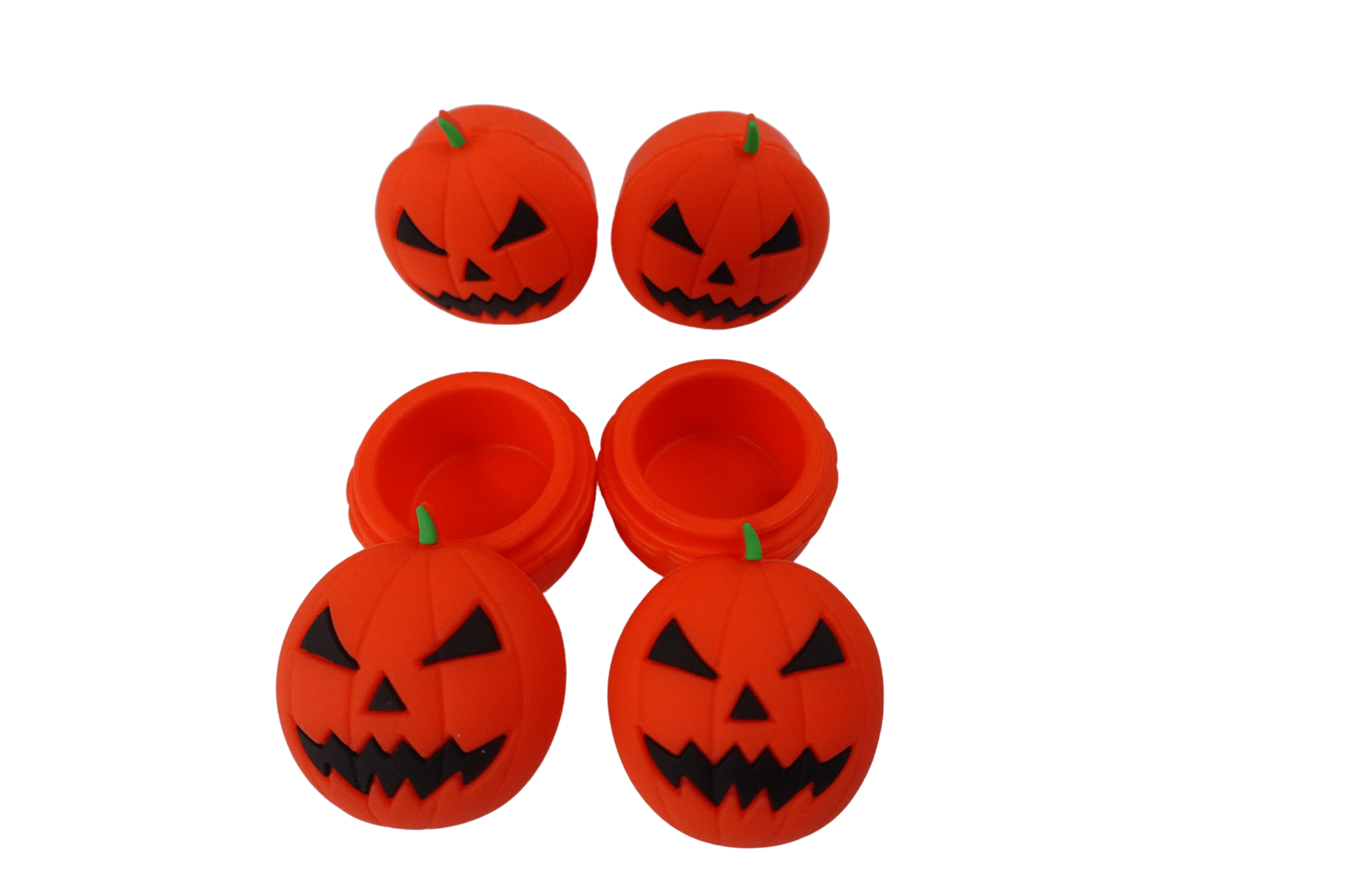 Top-down view of four 15 ml Pumpkin Silicone Wax Oil Concentrate Vaporizer Cream Container jack-o'-lantern lids and two open orange bases on a black background
