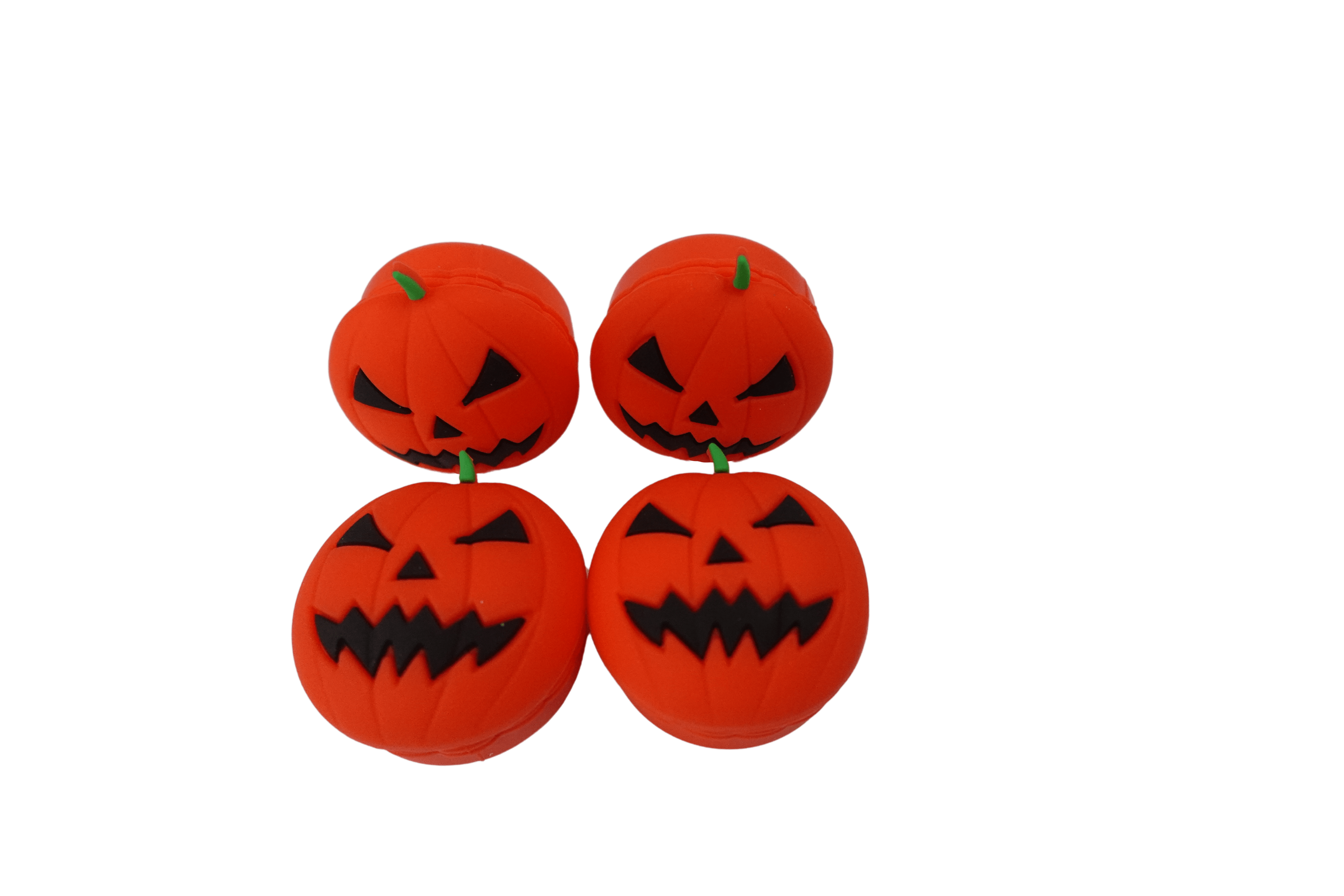 Front-facing close-up of four 15 ml Pumpkin Silicone Wax Oil Concentrate Vaporizer Cream Container jack-o'-lantern faces on a black background