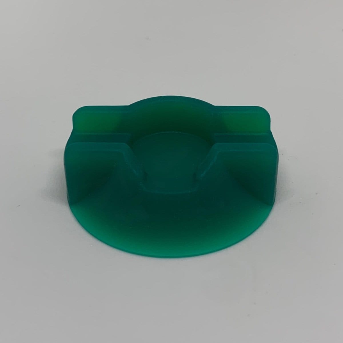 Front view of the V2 Dabber Dock®, a dark-colored, rounded stand with a recessed area.