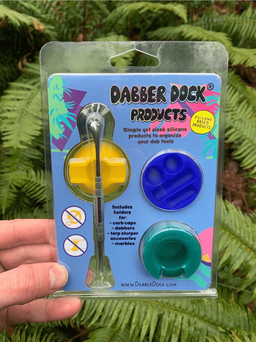 A close-up of the New Drop 3-pack *includes dabber*, showcasing the silicone tools against a black background with branded packaging.