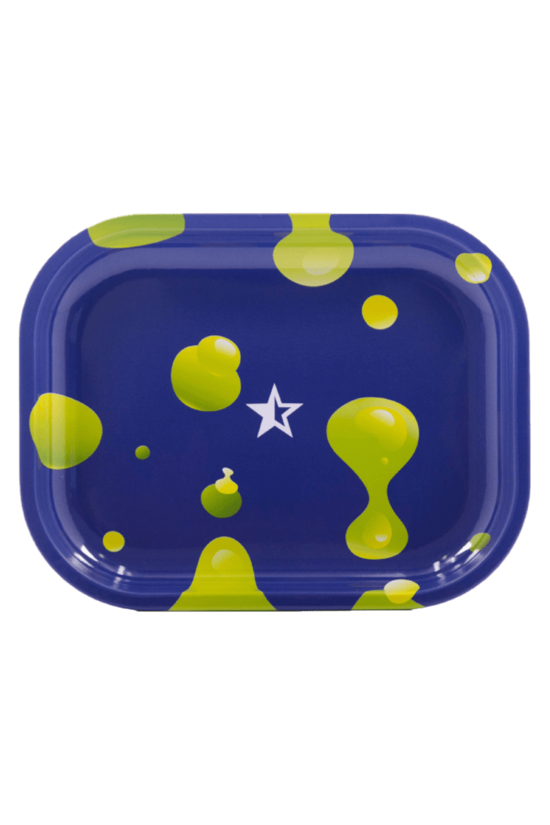 A slightly angled view of the Famous X $30 Kit with scattered, vibrant yellow droplets against a dark backdrop.