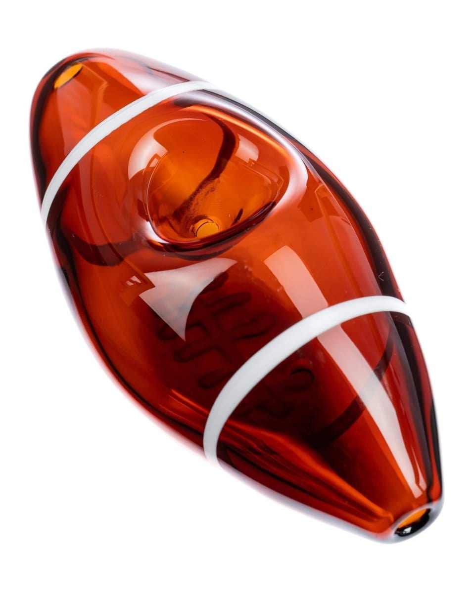 A diagonally angled view of the Football Hand Pipe, showcasing its smooth, sculpted form in a rich amber hue.