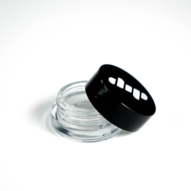 A slightly angled view of the clear glass Dip Devices Glass Jar, with a black lid resting on a white surface.