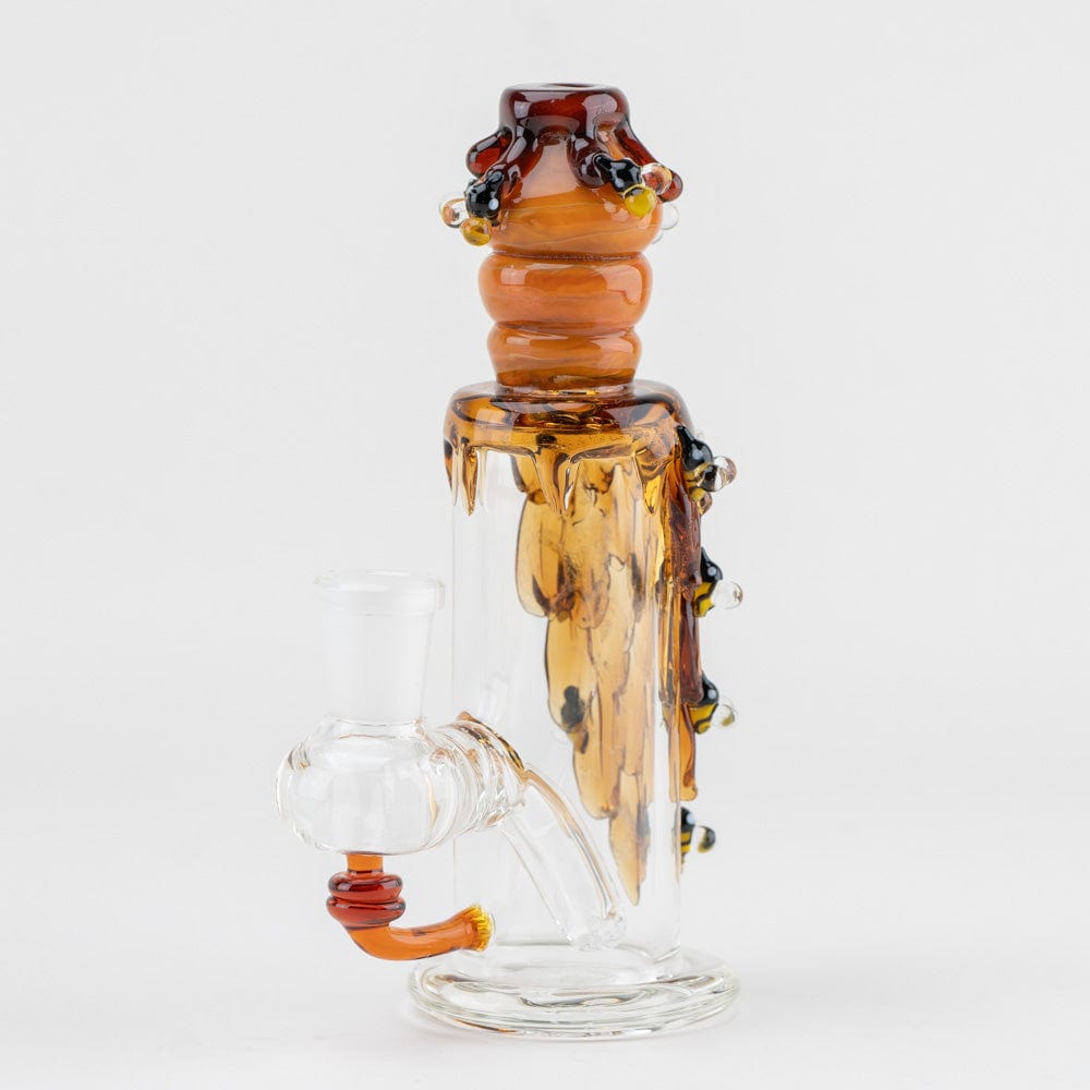 A close-up of the Beehive Nano Rig, showing its honey-colored glass with a unique, flowing design.