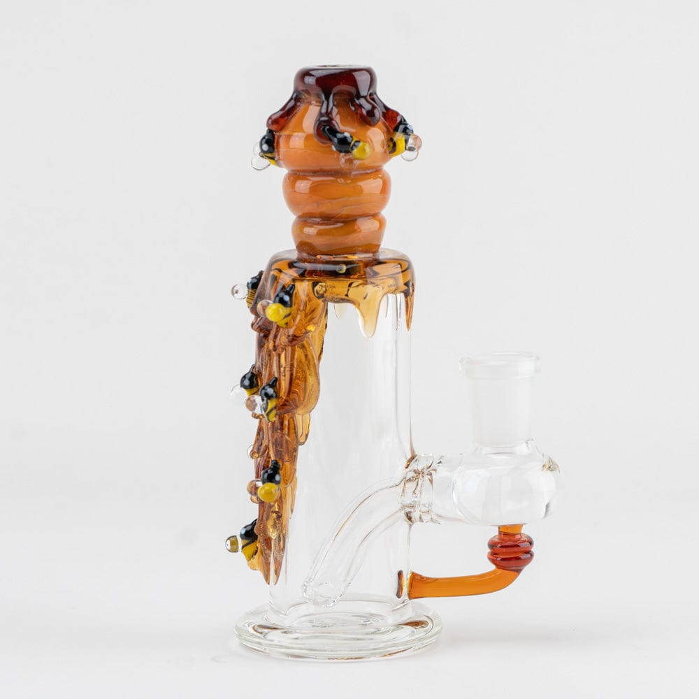 Front view of the Beehive Nano Rig, featuring a clear glass piece with honey-toned accents forming a unique, sculptural shape.