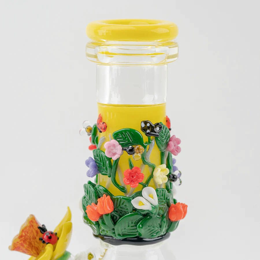 A vibrant, close-up view of the Sunshine Garden Beaker Water Pipe, adorned with colorful floral details against a neutral backdrop.