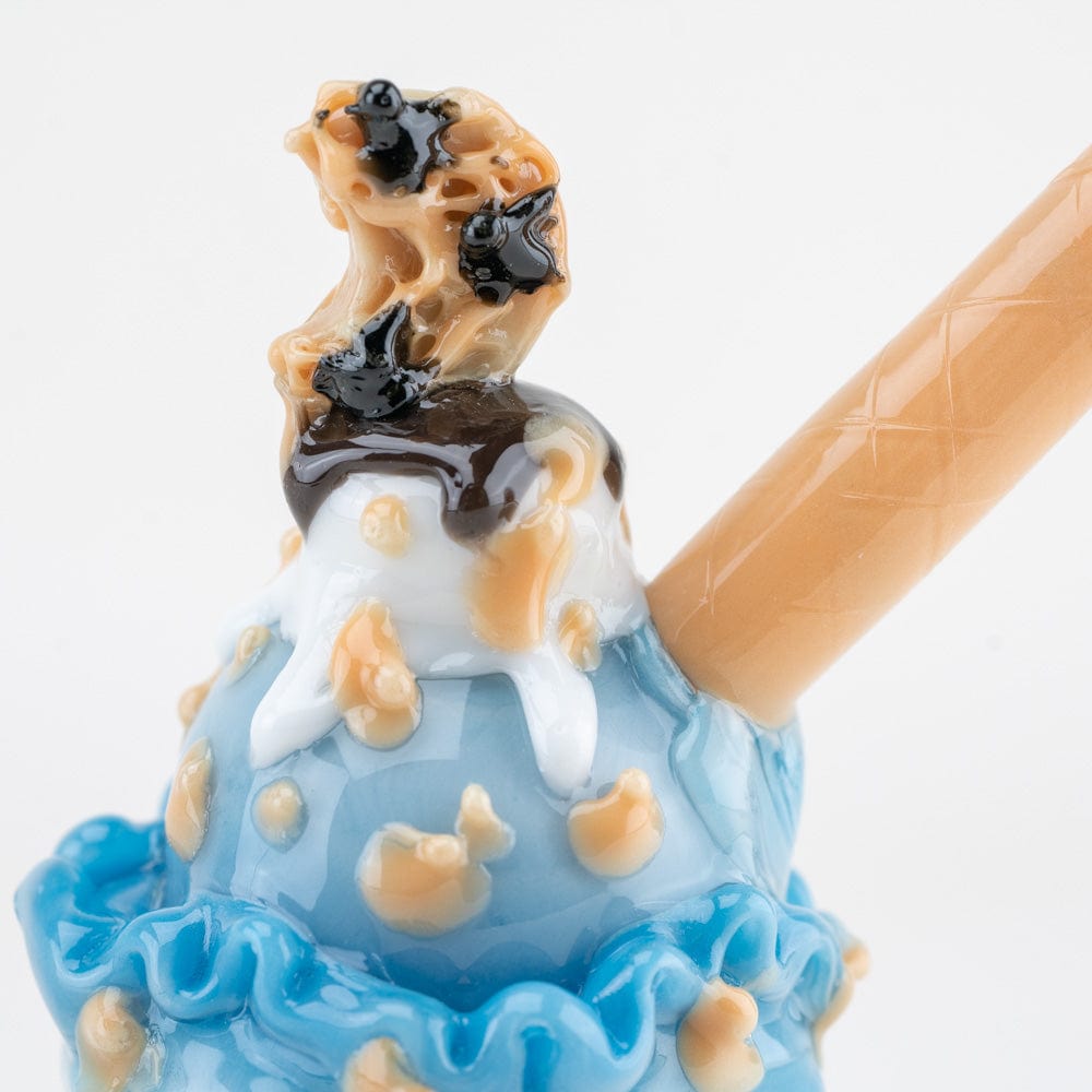 Close-up front view of the Cookie Monster Sundae Nano Rig showing glossy blue "ice cream" swirls, tan cookie bits, white drips and a textured tan straw.