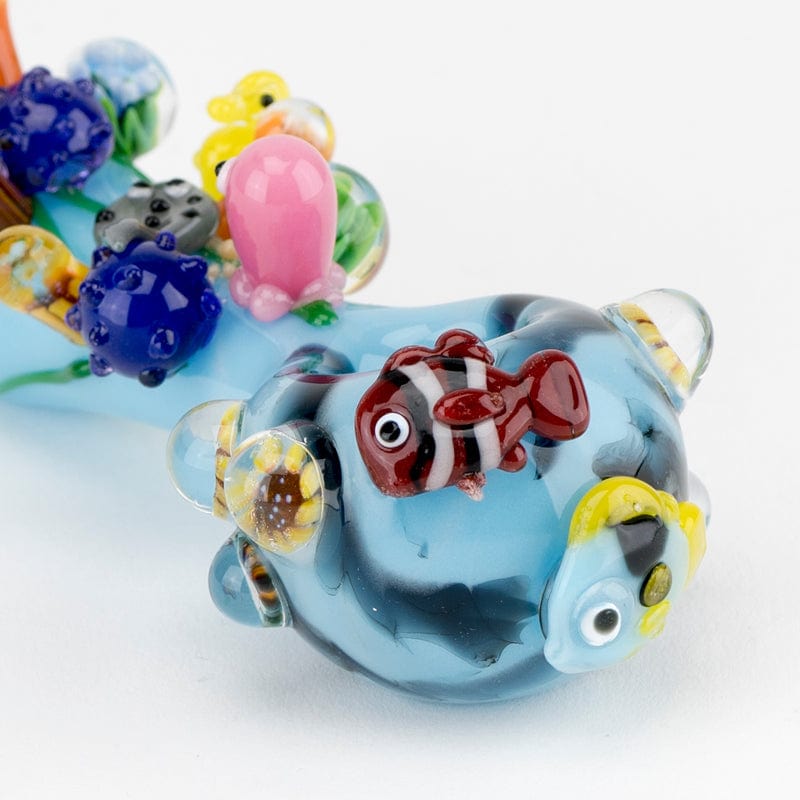 Close-up of the Great Barrier Reef Small Spoon Pipe, displaying colorful sculpted coral and aquatic life along its curved glass body.