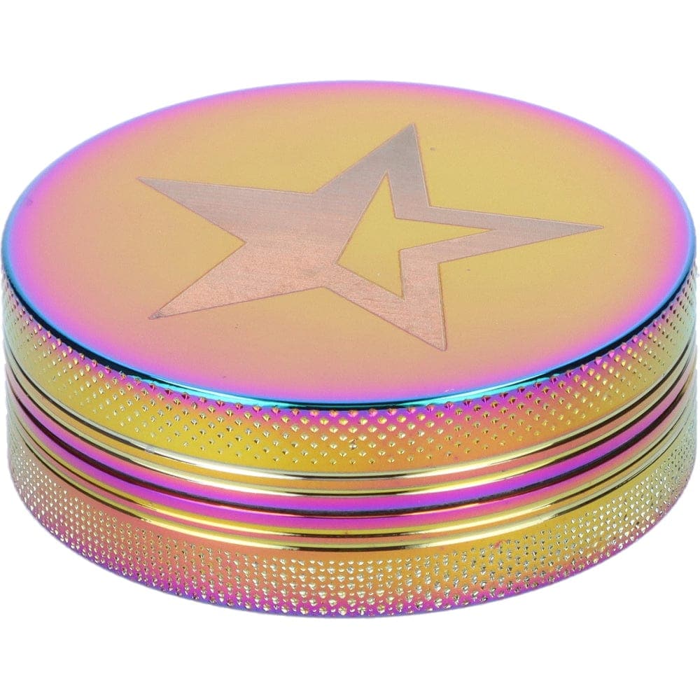 A close-up, angled view of the Famous X 55mm 1-Stage Grinder, featuring a prism-like, iridescent finish and textured metal construction.