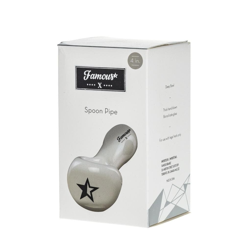 A close-up of the Famous X 4” Spoon Pipe, showing its smooth, clear glass construction and simple design.