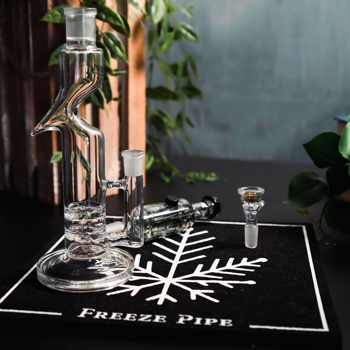 A studio shot features the Freeze Pipe Tornado, a clear glass pipe displayed on a dark surface.