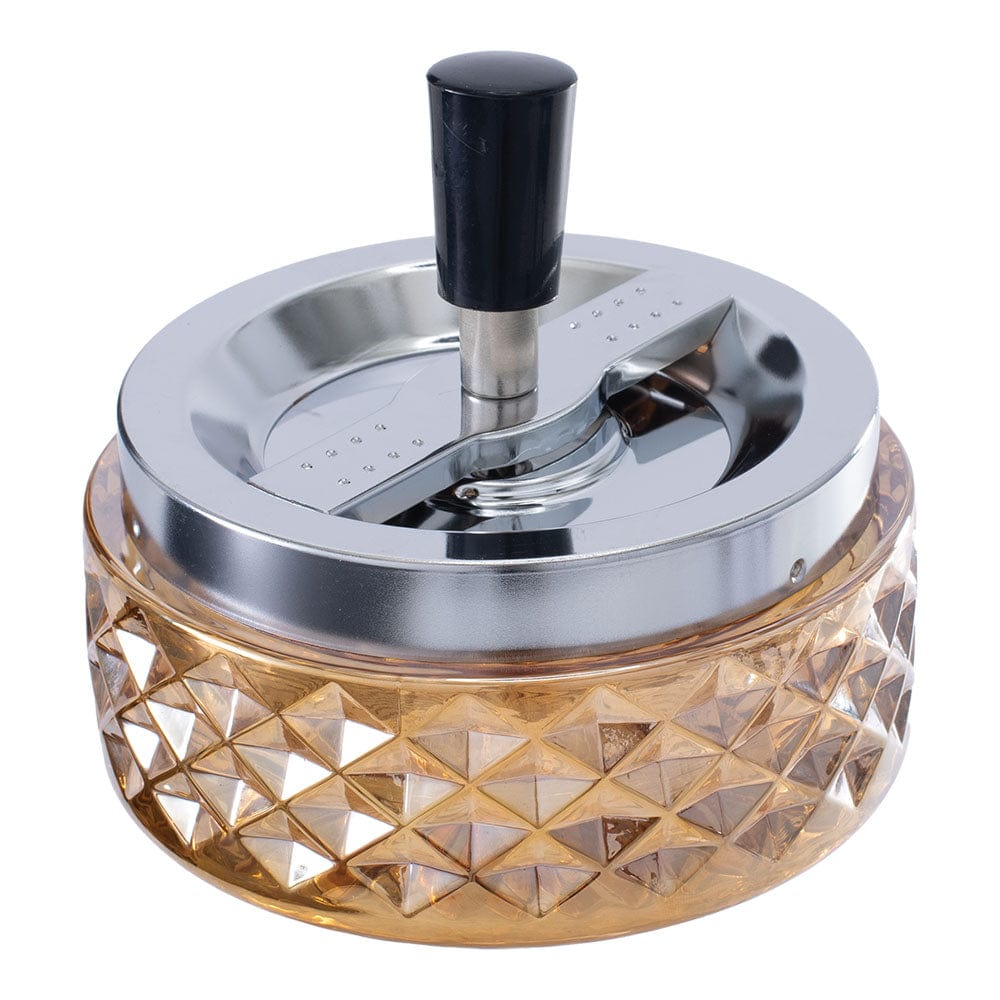 A close-up, angled view of the Gem-cut Glass Spinning Ashtray, showcasing its textured glass and rotating design.