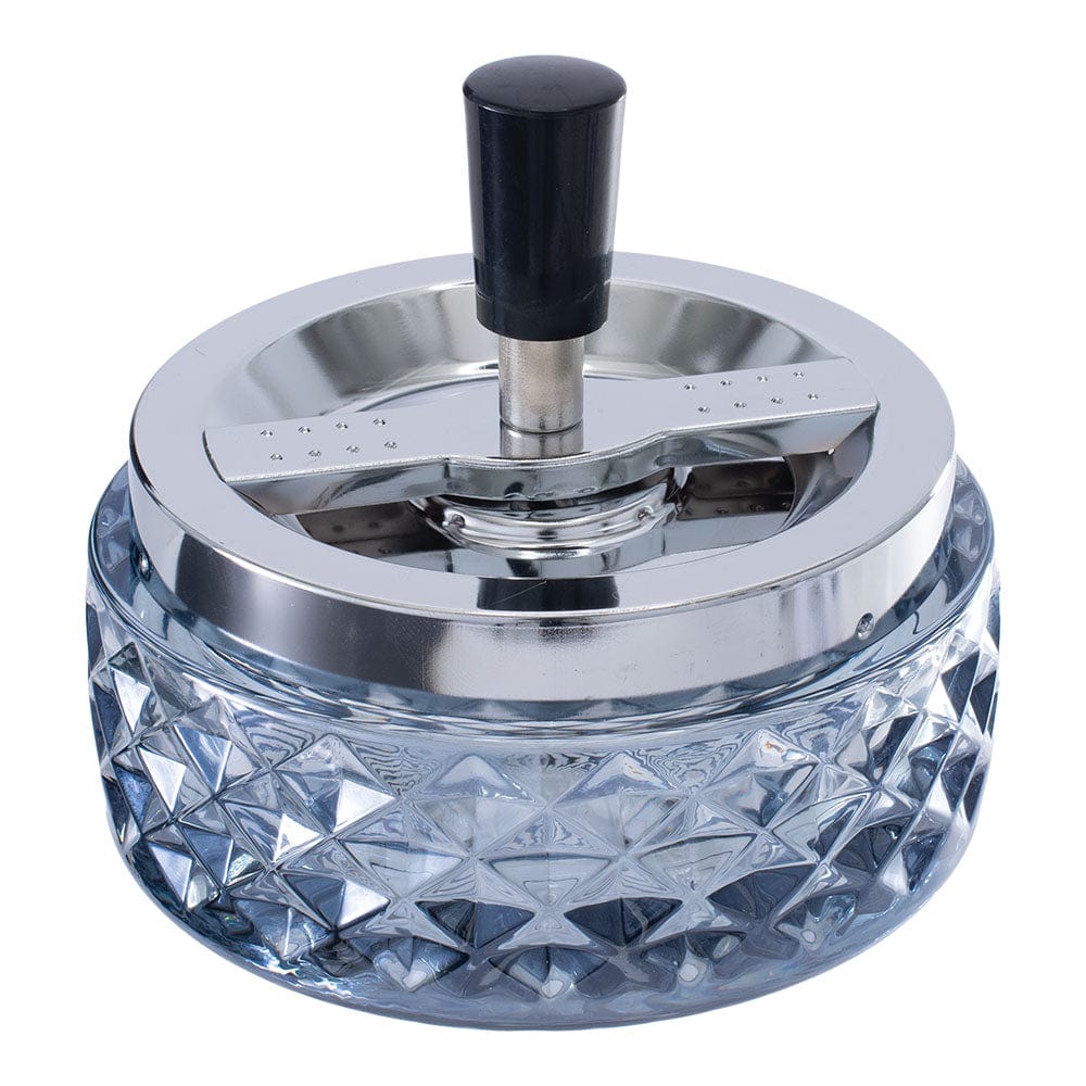 A close-up, angled view of the Gem-cut Glass Spinning Ashtray, showing its faceted clear glass design.