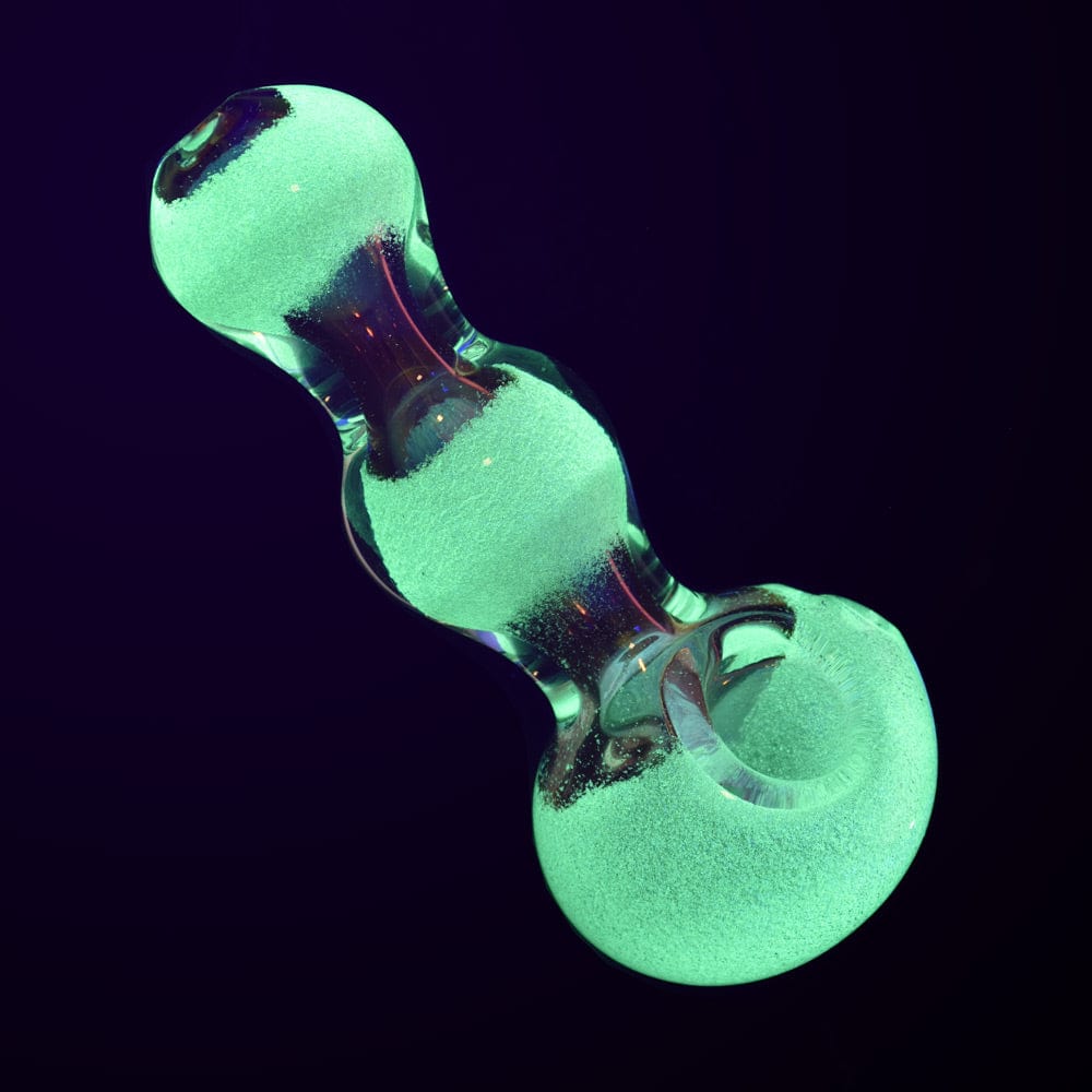 A close-up, angled view of the Triple Glow Bubble Fumed Spoon Pipe, showing its vibrant, glowing glass finish against a dark background.