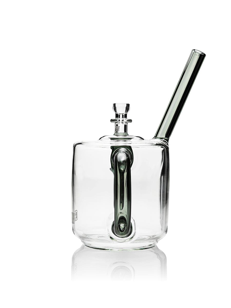 A three-quarter view of the GRAV® Coffee Mug Bubbler, crafted from clear glass and reflecting off a shiny surface.