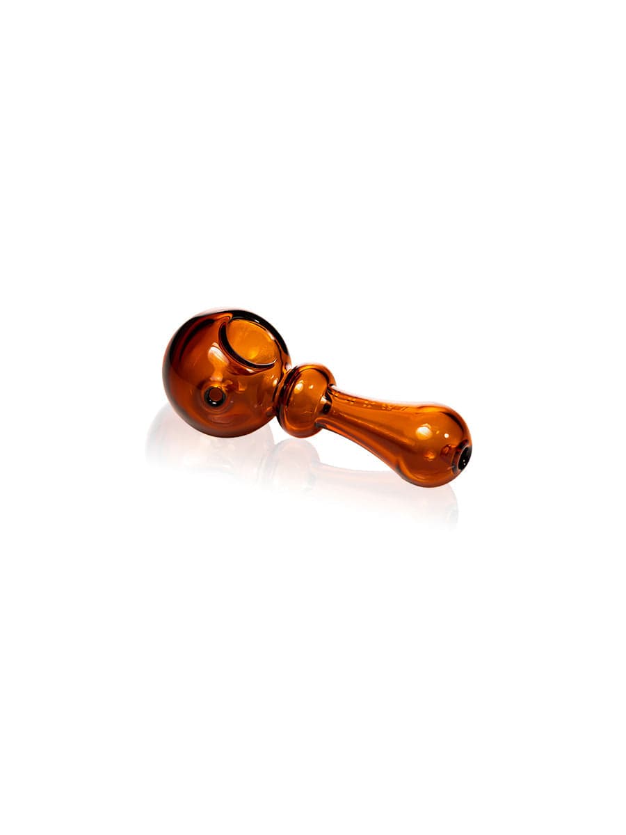 A side view of the GRAV® Bauble Spoon in amber glass, showing its curved bowl and smooth design against a plain white background.