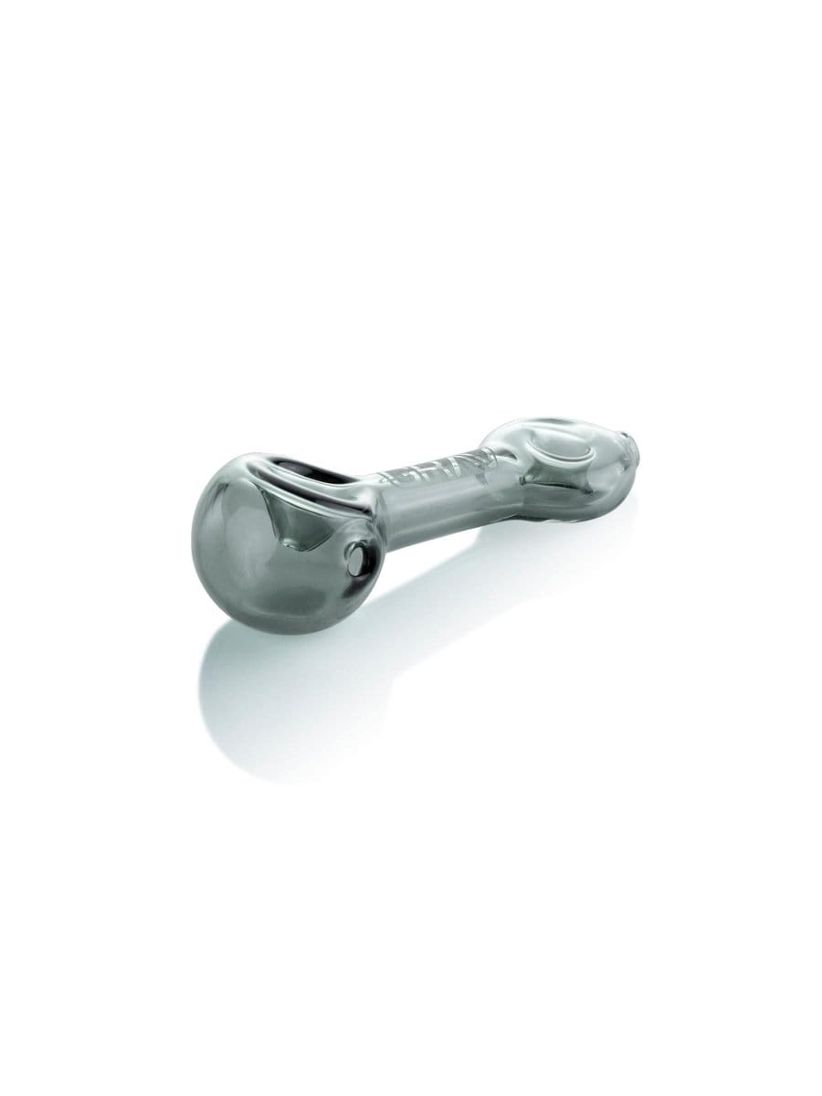 A side view of the GRAV® Mini Spoon Pipe, showcasing its curved design and clear glass construction against a reflective surface.