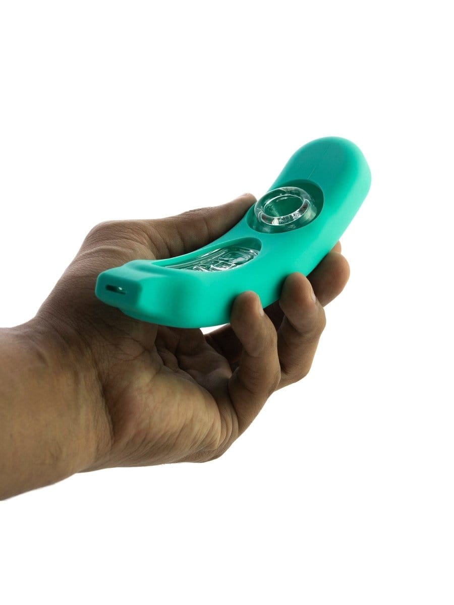 A hand holds the GRAV® Rocker Steamroller with Silicone Skin, showcasing its streamlined design and dark-colored protective layer.