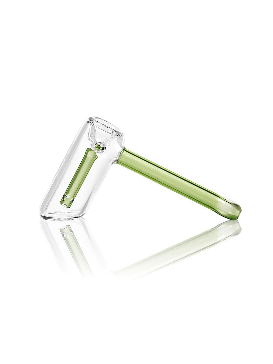 A diagonal, angled view of the GRAV® Mini Hammer Bubbler in clear glass, reflecting on a glossy surface.