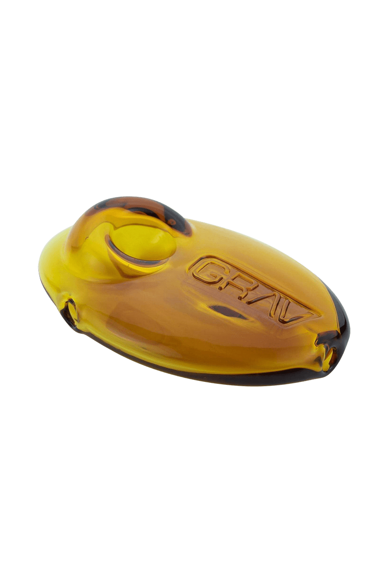 A close-up shot of the Grav Labs Pebble Spoon, showcasing its smooth, rounded shape and amber-colored glass.