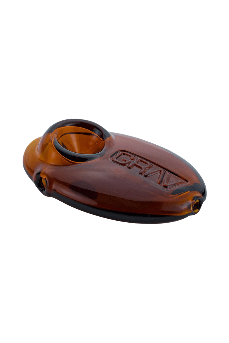 A side view of the Grav Labs Pebble Spoon, showing its smooth, rounded shape and dark amber glass.